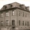 Multistory brick building with mansard roof and stairs