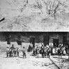 African-American children and faculty standing outside single-story brick building