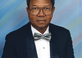 African-American man with glasses in suit and bow tie