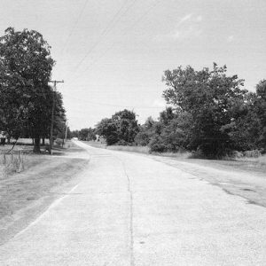 Highway section with house and power lines in the background