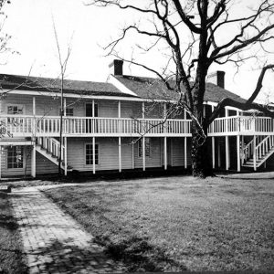 Two-story building with covered walkway and balcony on grass