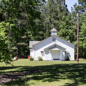 Single-story building with covered porch and cupola on its roof