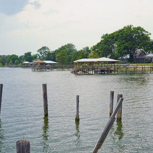 Row of boat docks on lake with house