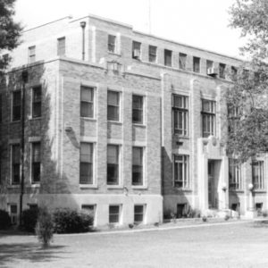 Four-story brick building with trees and grounds