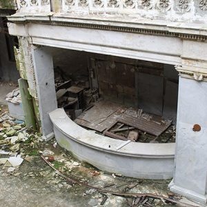 Abandoned ornate hotel lobby and desk with debris