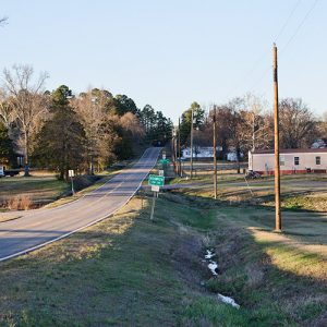 Highway section with road signs and houses on both sides