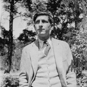 White man in suit and tie standing outdoors with his hands in his pockets