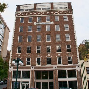 Looking up from the street at multistory brick hotel building with "Howe Hotel" sign