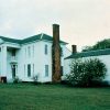 Multistory house with four columns and brick chimneys