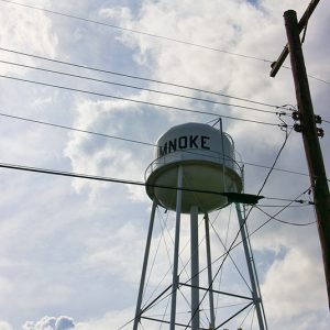 Looking up at water tower through power lines