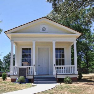 small white building with columns and glass windows