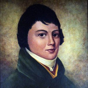 Young man with dark hair in a green suit and white collar