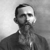 White man with long beard in suit and tie