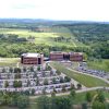 aerial view of two brick and glass buildings with large sprawling parking lot