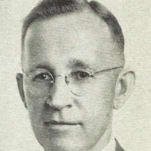 White man with glasses in suit and tie