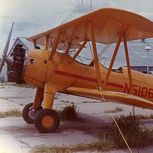 Yellow biplane with orange stripe and lettering