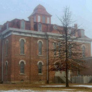 Multistory brick building with mansard roof and tower