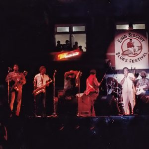 African-American guitar and brass band on stage