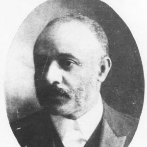 African-American man in suit with Maltese cross lapel pin