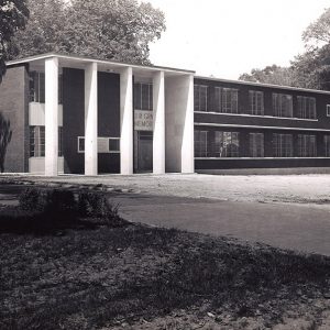 Two story brick building with covered entrance and flat roof