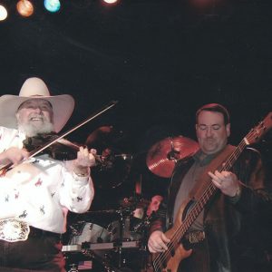 Two white men playing violin and bass on stage