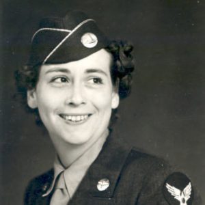 Young white woman smiling in military uniform with cap