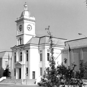 Two-story building with clock tower topped by dome