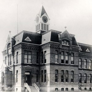 Multistory brick building with mansard roof and clock tower