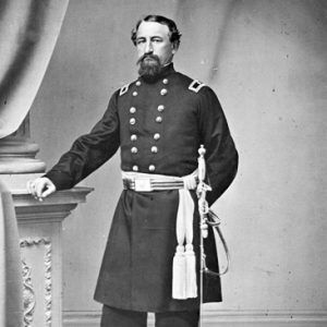 White man with beard posing in military uniform with sword