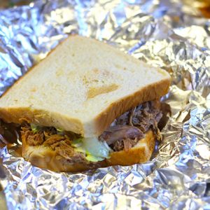 Barbecued pork on white bread in aluminum foil