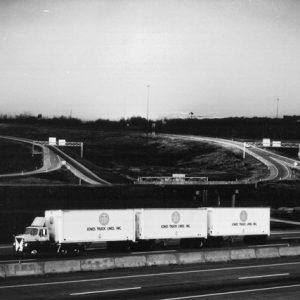 Semi-truck with three trailers on interstate