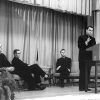 White men in clerical collars on stage watching white man speak at lectern