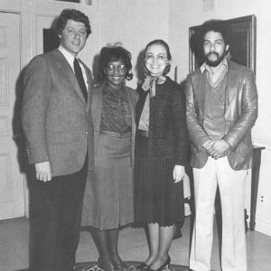 White man and woman with black man and woman standing in an entryway