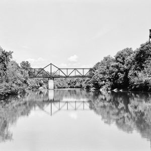 Steel truss bridge over river with concrete column