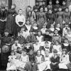 White women and girls on steps of school building