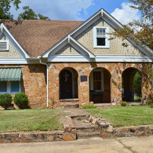 House with stone walls and three arches in front