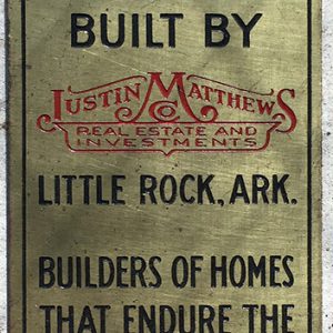 Engraved brass plaque with "Justin Matthews Real Estate and Investments" logo in red