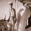 Old white man in hat and suit on ship deck