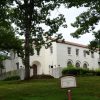 Two story white house with red tile roof