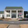 Two-story building with single-story wings and parking lot "Jacksonville Museum of Military History"