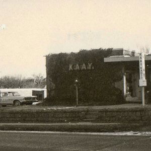 Car parked outside single-story "K.A.A.Y." building on street