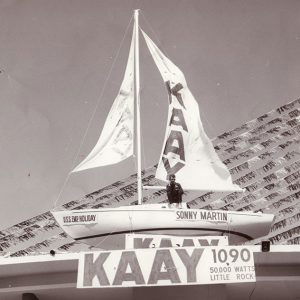 Man standing in small boat on roof of building