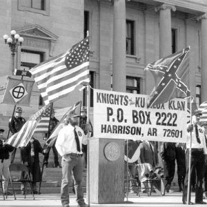 White men with flags and "Knights of the Ku Klux Klan" sign from Harrison speaking at the State Capitol