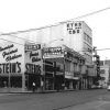 Multistory buildings with neon signs and other signs on city street