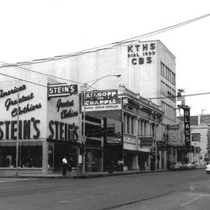 Multistory buildings with neon signs and other signs on city street