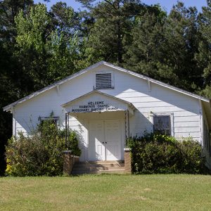 Single-story building with white siding and covered entrance