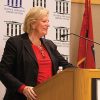 White woman speaking at lectern