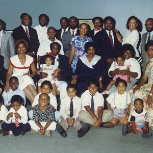 Group of dressed-up African-American men women and children sitting and standing together