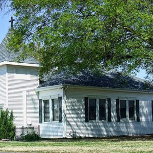 Single-story building with white wood siding and tower entrance