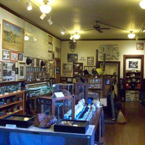 Mine cart framed photographs and equipment on display in room with hardwood floors